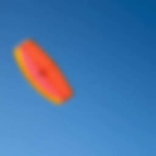 A vibrant sport kite soaring against a clear blue sky
