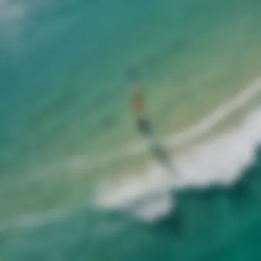 An aerial view of kiteboarders gliding across turquoise waters