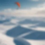 A stunning landscape of snow-covered terrain with a kite surfer soaring through the air.