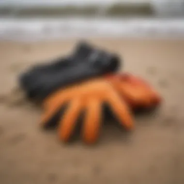 Diverse range of 5mm surfing gloves displayed on a sandy beach