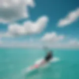 A kiteboarder gliding over turquoise waters under a clear sky