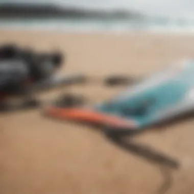 Close-up of kiteboarding equipment laid out on the sandy beach