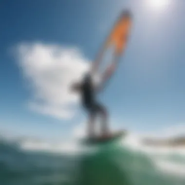 A kiteboarder soaring through the air with a vibrant kite against a clear blue sky