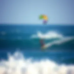 A colorful kitesurfing kite soaring high above the ocean waves